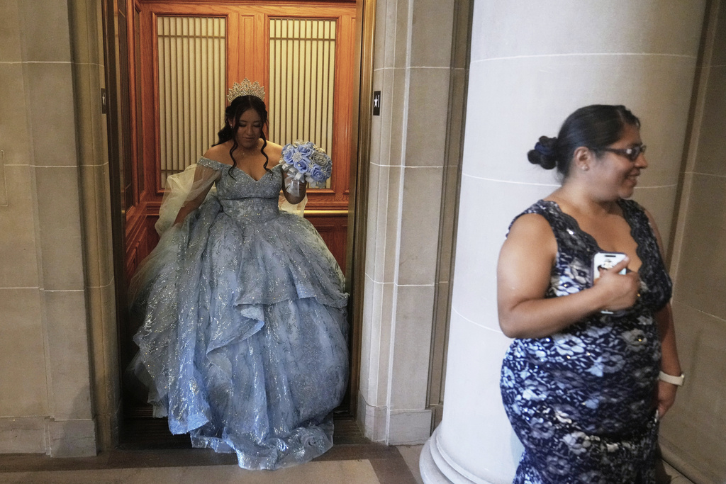 Abbie Gonzalez exits the elevator behind her mother Anna Gonzalez after her quinceañera portrait session at City Hall in San Francisco, Monday, Aug. 25, 2025. (AP Photo/Jeff Chiu)
