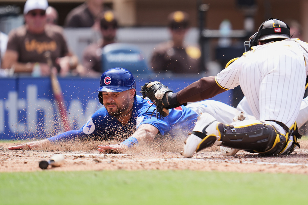 Chicago Cubs' Michael Conforto, left, slides in to score off an RBI groundout by Pete Crow-Armstrong as San Diego Padres catcher Luis Campusano is late with the tag during the sixth inning of a baseball game Wednesday, April 29, 2026, in San Diego. (AP Photo/Gregory Bull)