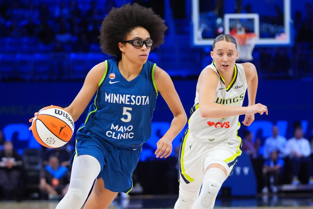 Minnesota Lynx guard Olivia Miles (5) drives past Dallas Wings guard Paige Bueckers during the second half of a WNBA basketball game in Arlington, Texas, Thursday, May 14, 2026. (AP Photo/LM Otero)