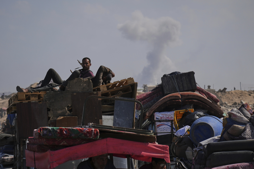 Smoke rises in the background following Israeli bombardment as displaced Palestinians flee northern Gaza, Tuesday, Sept. 16, 2025, after Israel's military says its expanded operation in Gaza City has begun and warns residents to leave. (AP Photo/Abdel Kareem Hana)