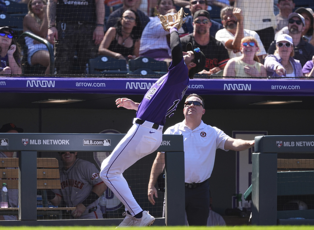 Colorado Rockies third baseman Kyle Karros pulls in a pop foul off the bat of San Francisco Giants' Willy Adames to end the top of the third inning of a baseball game Monday, Sept. 1, 2025, in Denver. (AP Photo/David Zalubowski)