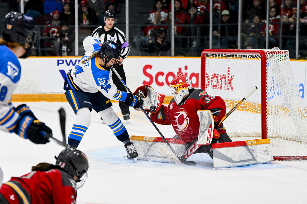 Ottawa Charge's goaltender Gwyneth Philips (33) tries to make a save while being pressured by Toronto Sceptres' Renata Fast (14) during the second period of a PWHL hockey game in Ottawa, Ontario, Saturday, April 25, 2026. (Spencer Colby/The Canadian Press via AP)