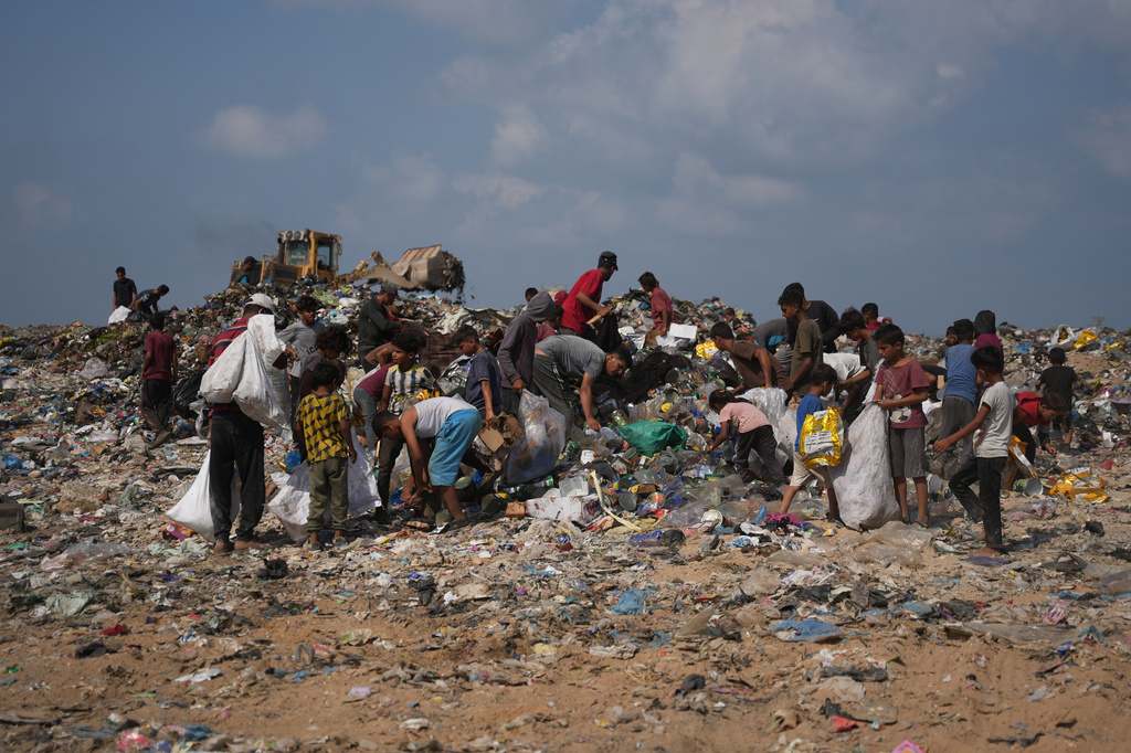 Palestinians search through a garbage dump for combustible materials to use as fuel for cooking due to a shortage of cooking gas, in Deir al-Balah, central Gaza Strip, Saturday, Aug. 22, 2026. (AP Photo/Abdel Kareem Hana)