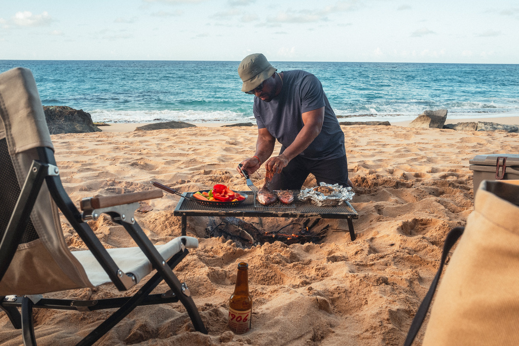 Rashad Frazier prepares food on a beach on Manatí, Puerto Rico. on Jan. 20, 2025. (Alex Forestier via AP)