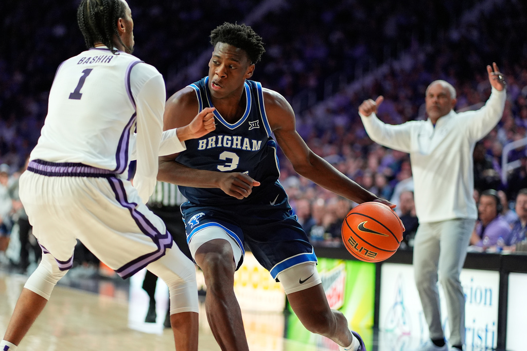 BYU forward AJ Dybantsa (3) looks to get past Kansas State guard Abdi Bashir Jr. (1) during the first half of an NCAA college basketball game Saturday, Jan. 3, 2026, in Manhattan, Kan. (AP Photo/Charlie Riedel)