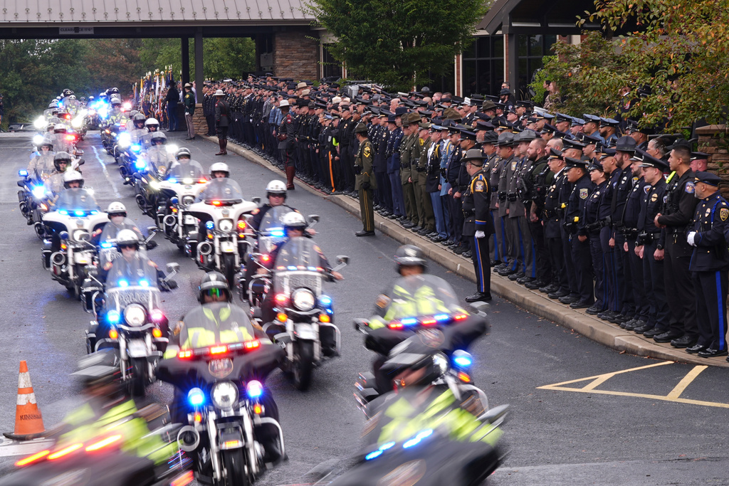 Officers watch a procession for slain Northern York County Regional Police detectives Cody Michael Becker, Mark Edward Baker and Isaiah Emenheiser, Thursday, Sept. 25, 2025, in Red Lion, Pa. (AP Photo/Matt Rourke)
