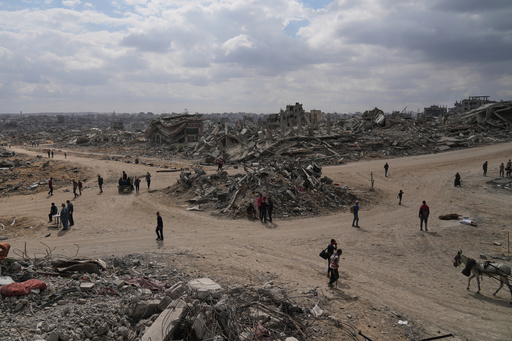 Displaced Palestinians walk amid destroyed buildings in Al-Jalaa Street in Gaza City, Sunday, Oct. 12, 2025, after Israel and Hamas agreed to a pause in their war and the release of the remaining hostages. (AP Photo/Abdel Kareem Hana) Displaced Palestinians walk amid destroyed buildings in Al-Jalaa Street in Gaza City, Sunday, Oct. 12, 2025, after Israel and Hamas agreed to a pause in their war and the release of the remaining hostages. (AP Photo/Abdel Kareem Hana)
