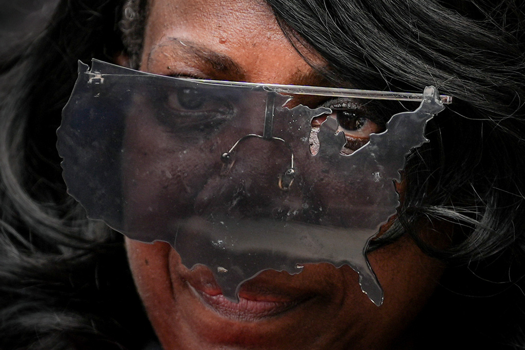 An activist wears United States-shaped sunglasses during the March on Washington, Friday, Aug. 28, 2026, in Washington. (AP Photo/Julia Demaree Nikhinson)