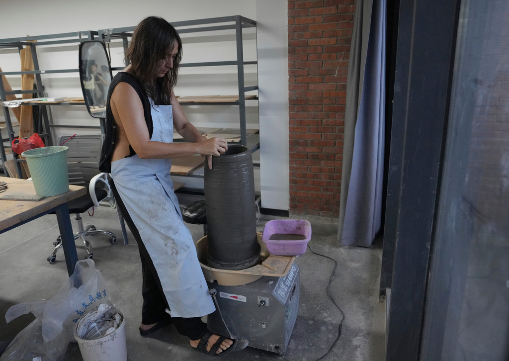 Italian ceramic artist Paola Masi works on a piece in Jingdezhen, known as China's "Porcelain Capital," in eastern China's Jiangxi province, Monday, Aug. 31, 2026. (AP Photo/Achmad Ibrahim)