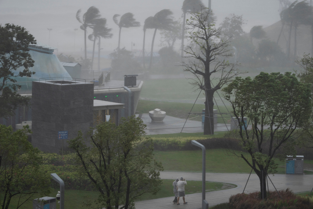 People walk in the rain and strong winds in Shenzhen in southern China's Guangdong province on Wednesday, Sept. 24, 2025, as Typhoon Ragasa moves near the area. (AP Photo/Ng Han Guan)