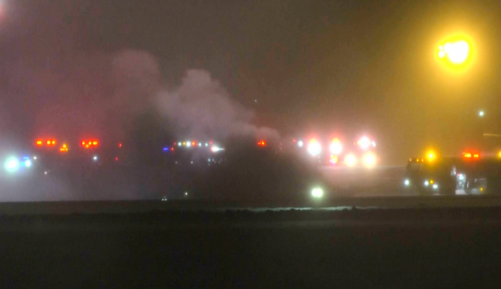 This image taken from video provided by WABI television, emergency cervices work on a scene of the Bombardier Challenger 600 crash at the Bangor Airport in Maine, late Sunday, Jan. 25, 2026. (WABI via AP)