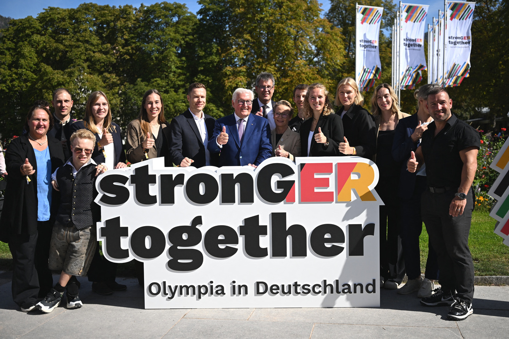 Germany's President Frank-Walter Steinmeier, center, with politicians and athletes pose for the media at the extraordinary DOSB General Assembly to select Germany's Olympic bid for 2036, 2040, or 2044, in Baden-Baden, Germany, Saturday Sept. 26, 2026. (Marijan Murat/dpa via AP)
