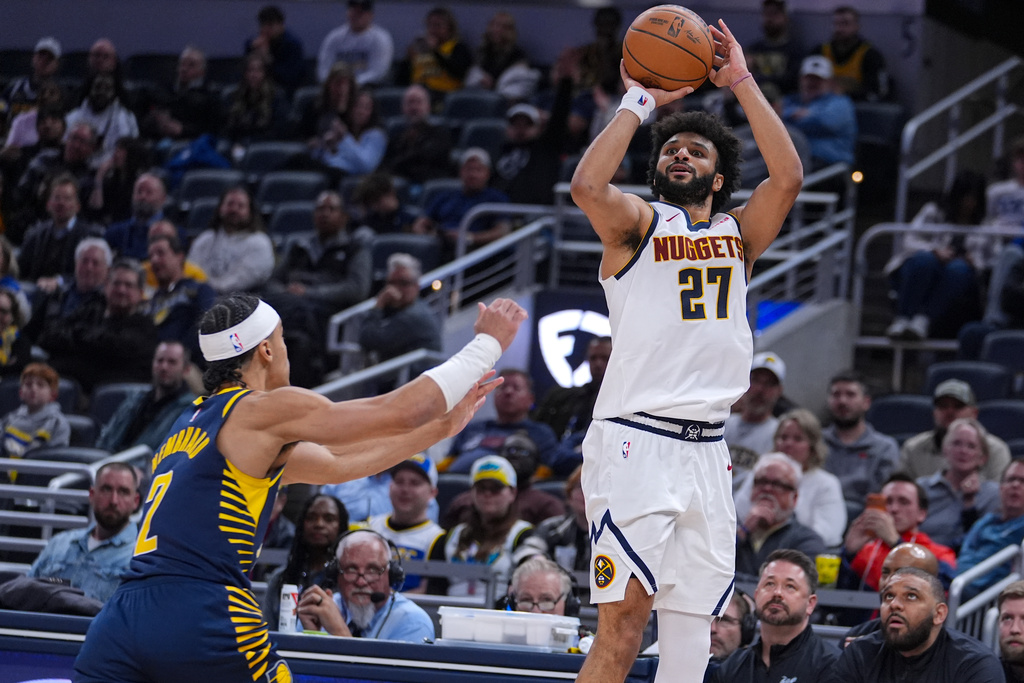 Denver Nuggets guard Jamal Murray (27) hits a three-point basket over Indiana Pacers guard Andrew Nembhard (2) for his 50th point during the second half of an NBA basketball game in Indianapolis, Wednesday, Dec. 3, 2025. (AP Photo/Michael Conroy)