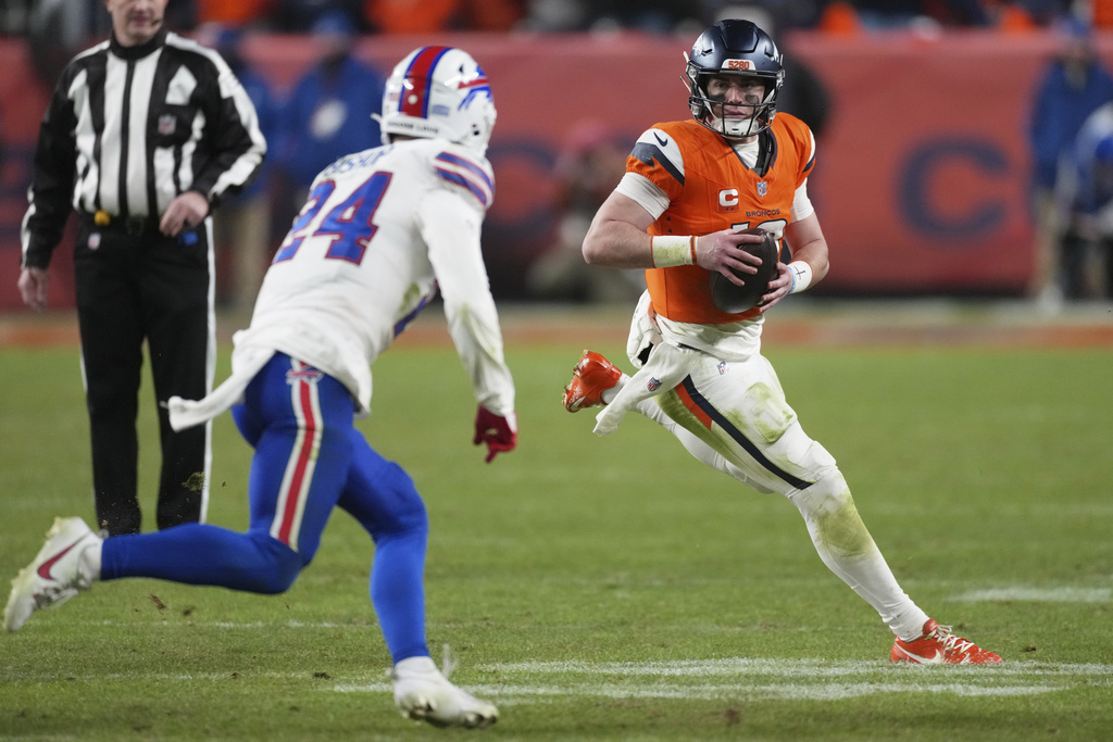 Denver Broncos quarterback Bo Nix, right, runs as Buffalo Bills safety Cole Bishop pursues in overtime of an NFL divisional football game Saturday, Jan. 17, 2026, in Denver. (AP Photo/David Zalubowski)