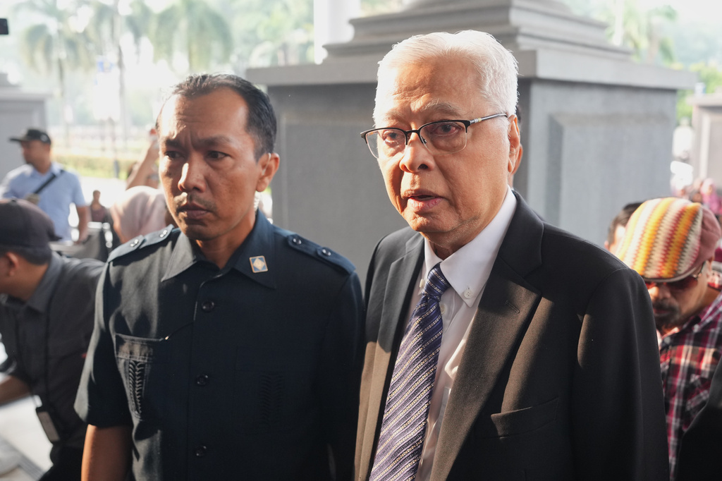 Malaysia's former Prime Minister Ismail Sabri Yaakob, right, arrives at courthouse for a corruption case in Kuala Lumpur, Malaysia, Thursday, Aug. 27, 2026. (AP Photo/Vincent Thian)
