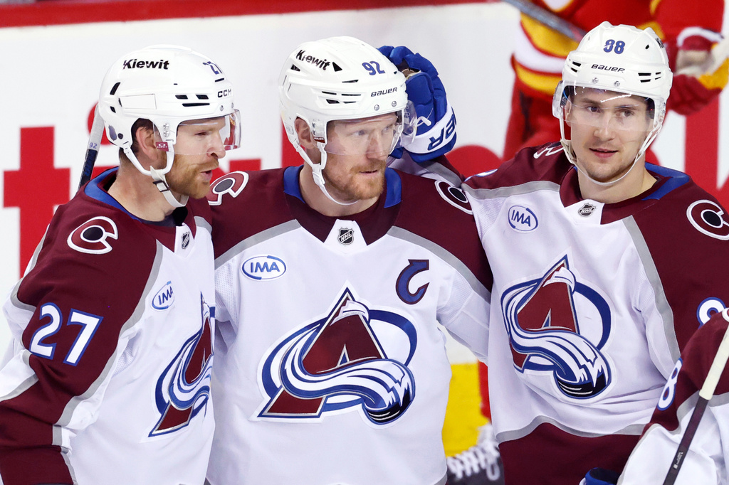 Colorado Avalanche's Gabriel Landeskog, center, celebrates his goal against the Calgary Flames with Brett Kulak, left, and Martin Necas during the third period of an NHL hockey game in Calgary, Alberta, Tuesday, April 14, 2026. (Larry MacDougal/The Canadian Press via AP)