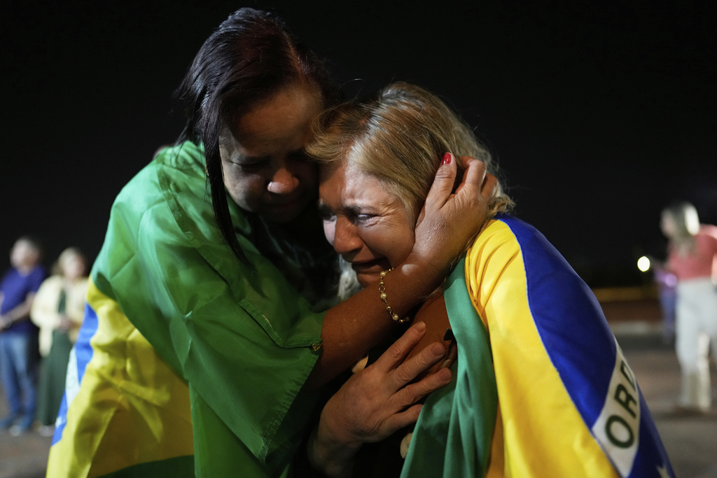 Supporters of former President Jair Bolsonaro cry during a vigil in his support near his home where he is under house arrest in Brasilia, Brazil, Thursday, Sept. 11, 2025. (AP Photo/Eraldo Peres)