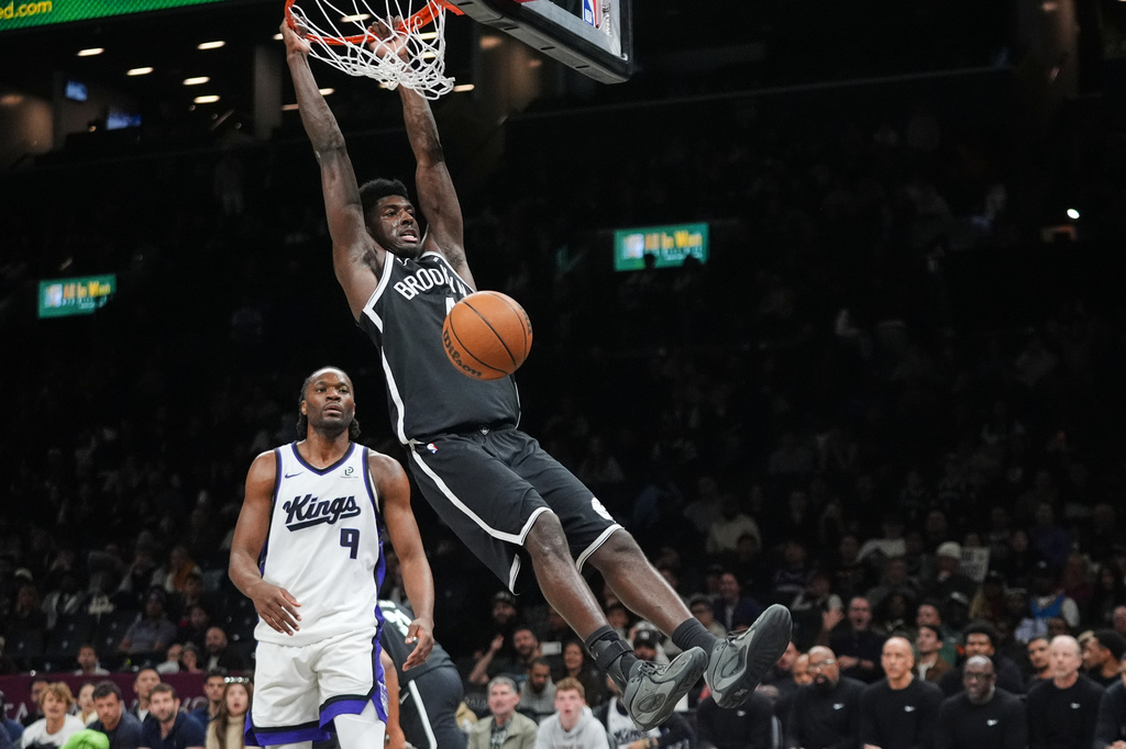 Brooklyn Nets' Drake Powell (4) dunks the ball in front of Sacramento Kings' Precious Achiuwa (9) during the second half of an NBA basketball game Sunday, March 29, 2026, in New York. (AP Photo/Frank Franklin II)