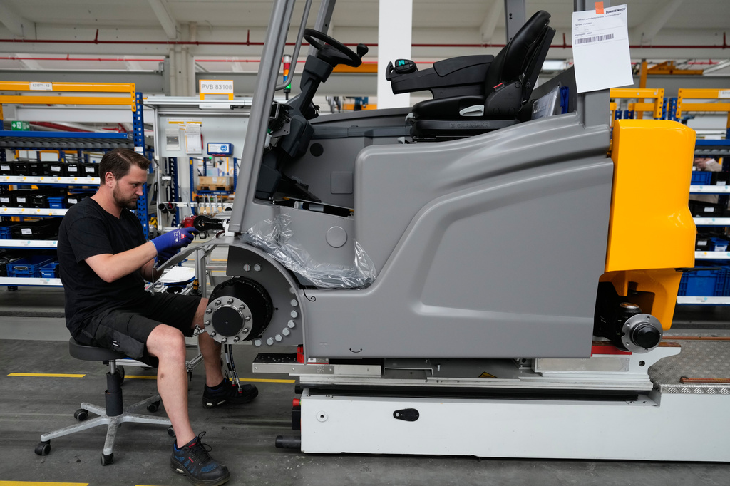 Employees at forklift and warehouse manufacturer Jungheinrich work on the assembly line in Moosburg, Germany, Tuesday, Aug. 25, 2026. (AP Photo/Matthias Schrader)