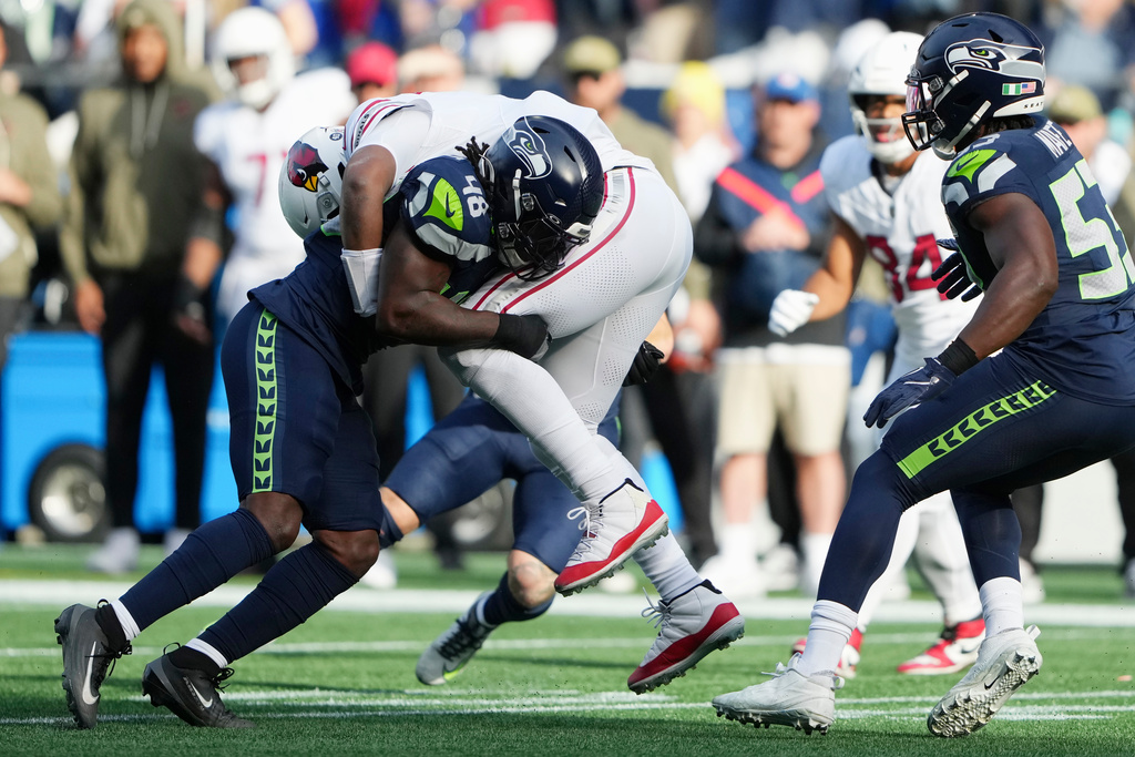 Seattle Seahawks linebacker Tyrice Knight (48) tackles Arizona Cardinals quarterback Jacoby Brissett as Seahawks linebacker Boye Mafe (53) looks on during the first half of an NFL football game Sunday, Nov. 9, 2025, in Seattle. (AP Photo/Lindsey Wasson)