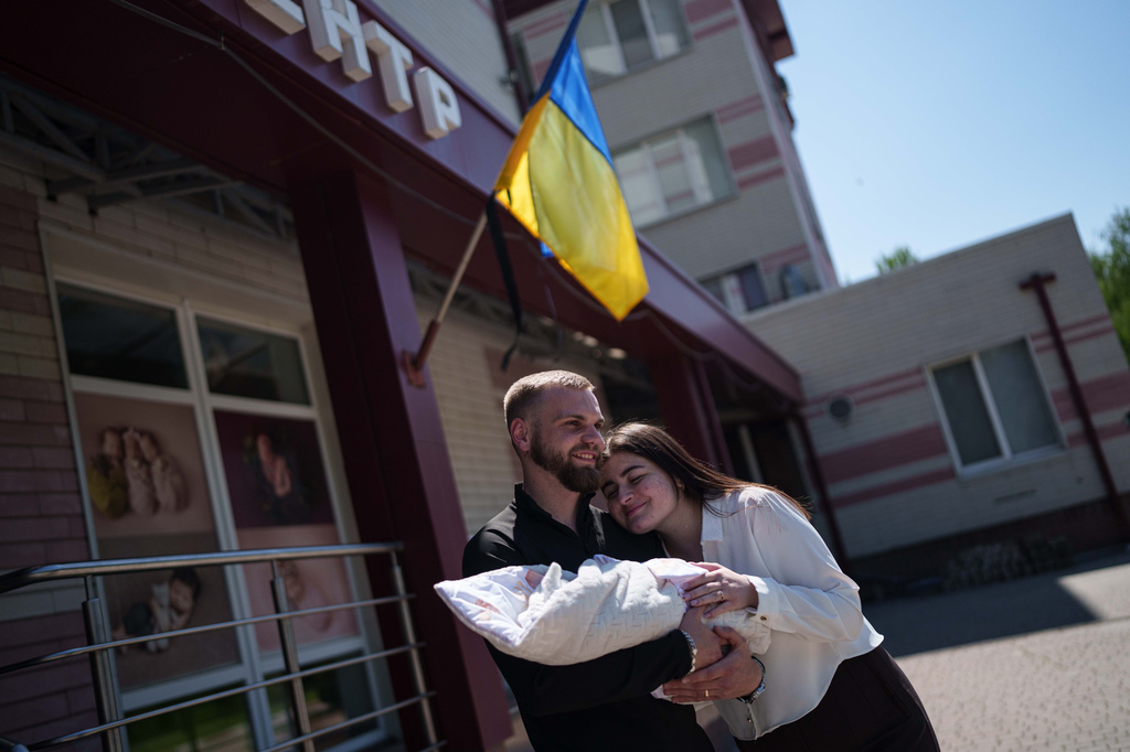 Mariia Skladan, right, her husband Vladyslav and their daughter Elina pose for a photo after mother and baby left the regional perinatal center of Zaporizhzhia, Ukraine, Wednesday, May 6, 2026. (AP Photo/Evgeniy Maloletka)