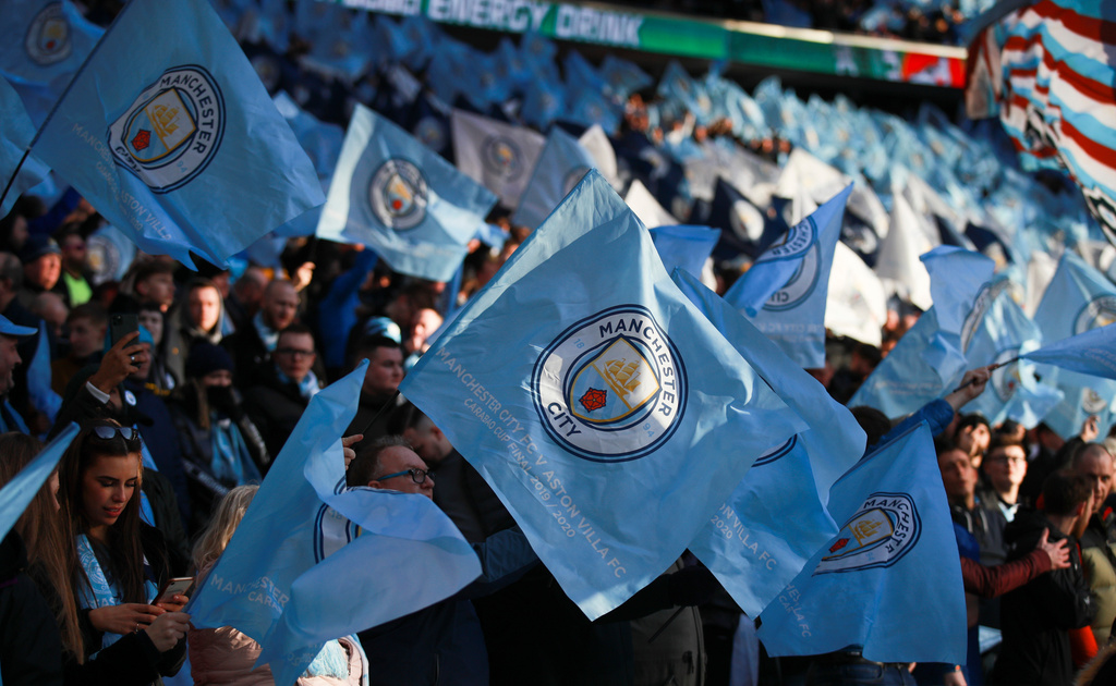 FILE - Manchester City fans wave the team's flag prior to the League Cup soccer match final between Aston Villa and Manchester City, at Wembley stadium, in London, England, Sunday, March 1, 2020. (AP Photo/Ian Walton, File)