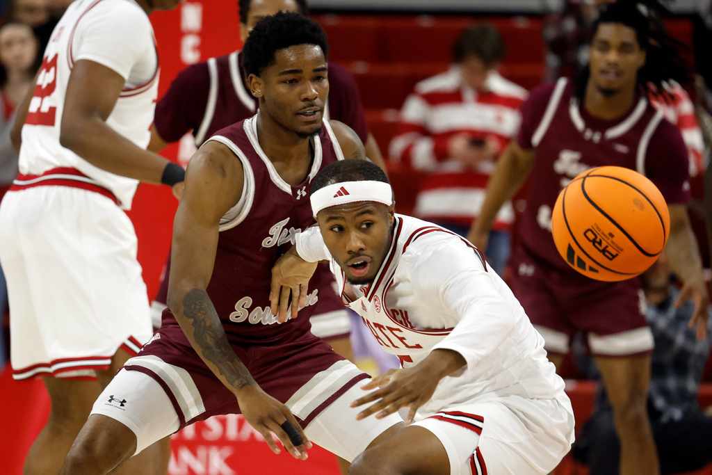 North Carolina State's Tre Holloman, center, looses control of the ball in front of Texas Southern's Jaylen Wysinger during the first half of an NCAA college basketball game in Raleigh, N.C., Wednesday, Dec. 17, 2025. (AP Photo/Karl DeBlaker)