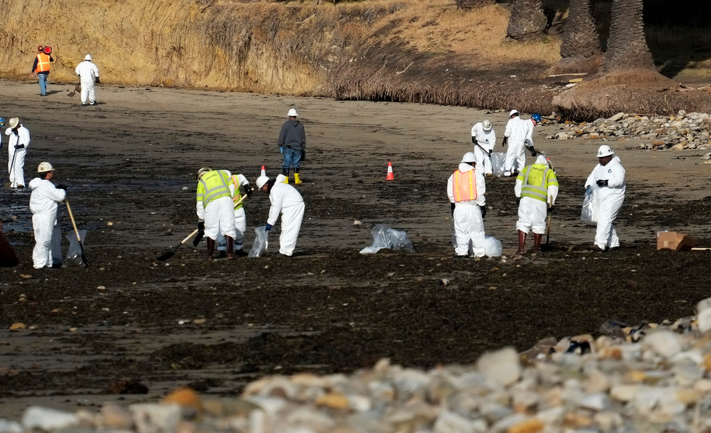 FILE - Clean up crews remove oil-laden sand on the beach at Refugio State Beach, site of an oil spill, north of Goleta, Calif., May 20, 2015. (AP Photo/Michael A. Mariant, File)