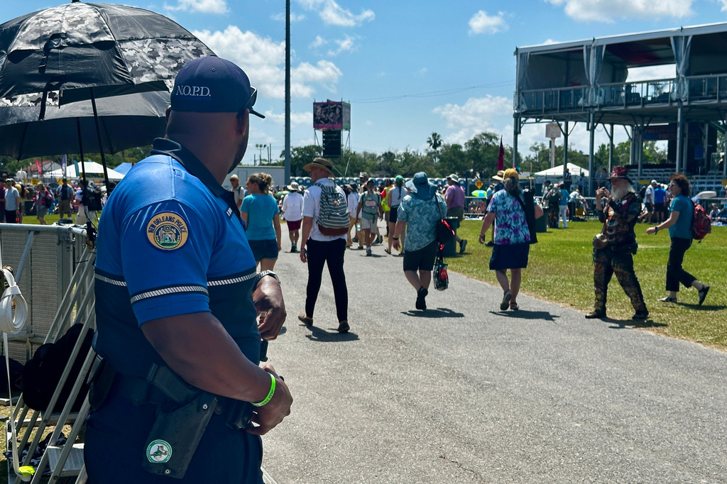 A New Orleans Police Department officer monitors a crowd on the first day of the 2026 New Orleans Jazz Heritage Festival in New Orleans on Thursday, April 23, 2026. (AP Photo/Stephen Smith)
