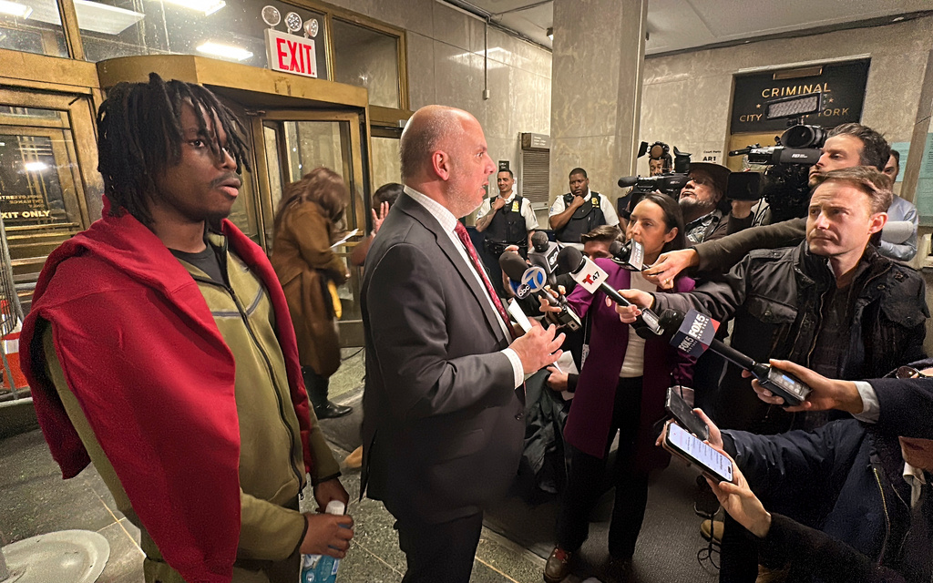 Gusmane Coulibaly, left, listens as his lawyer, George Vomvolakis speaks to members of the media after Coulibaly's initial court appearance, Thursday, Feb. 26, 2026, in New York, on charges alleging he threw a snowball at a police officer. (AP Photo/Michael Sisak)