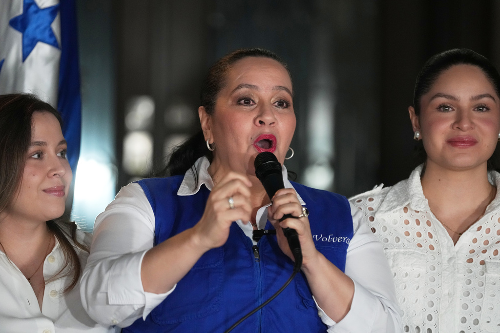 Ana García, center, wife of former Honduras' President Juan Orlando Hernández speaks to journalists in Tegucigalpa, Honduras, Friday, Nov. 28, 2025 after U.S. President Donald Trump said he would pardon Hernández, who is serving a 45-year prison sentence for helping import cocaine to the United States. (AP Photo/Moises Castillo)