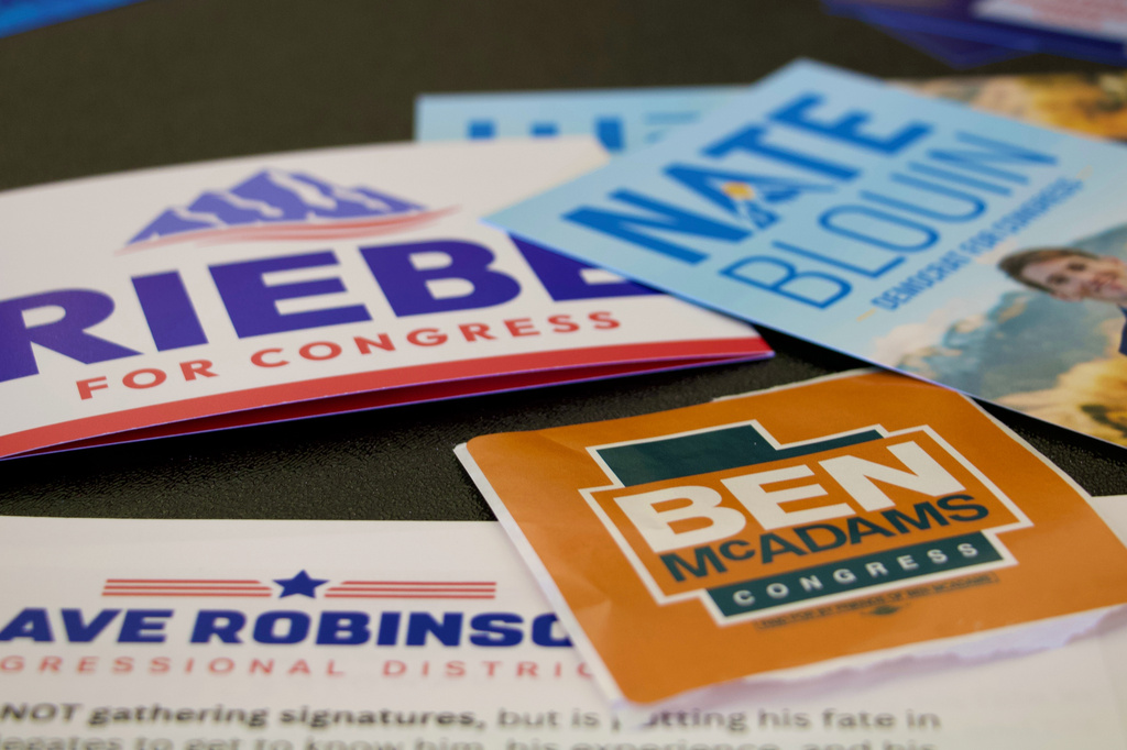 Candidate handouts are displayed at an event for candidates running to represent Utah's new Democratic-leaning congressional district, March 21, 2026, in Taylorsville, Utah. (AP Photo/Hannah Schoenbaum)