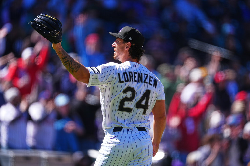 Colorado Rockies starting pitcher Michael Lorenzen calls for a new ball after giving up a three-run home run to Philadelphia Phillies' Brandon Marsh in the first inning of a baseball game Friday, April 3, 2026, in Denver. (AP Photo/David Zalubowski)