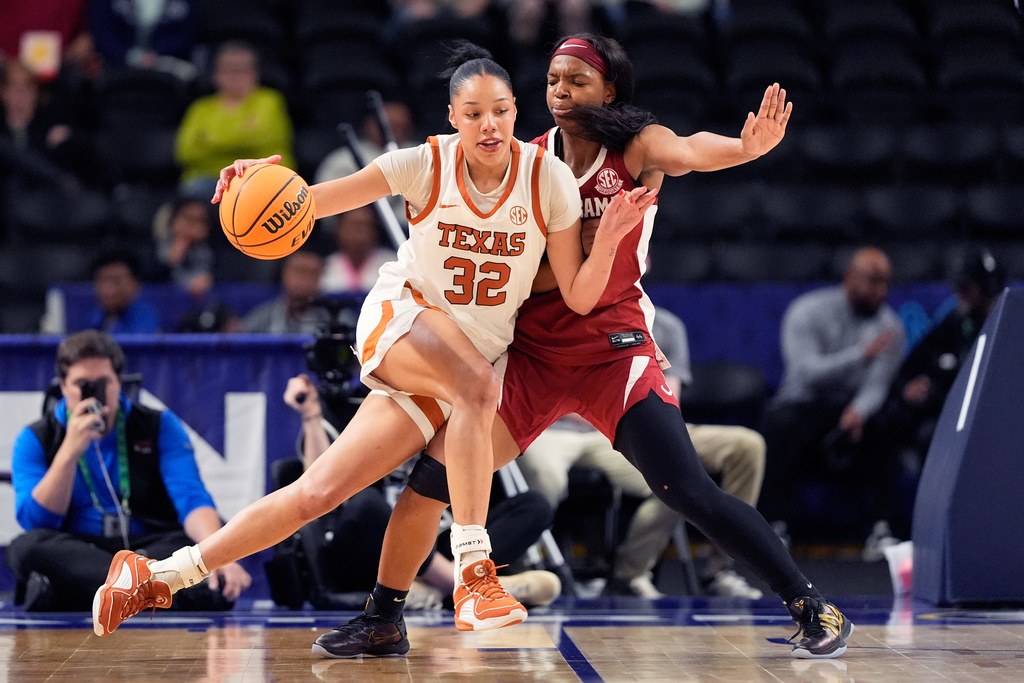 Texas forward Teya Sidberry drives to the basket past Alabama guard Jessica Timmons during first half of an NCAA college basketball game in the quarterfinals of the Southeastern Conference tournament, Friday, March 6, 2026, in Greenville, S.C. (AP Photo/Chris Carlson)