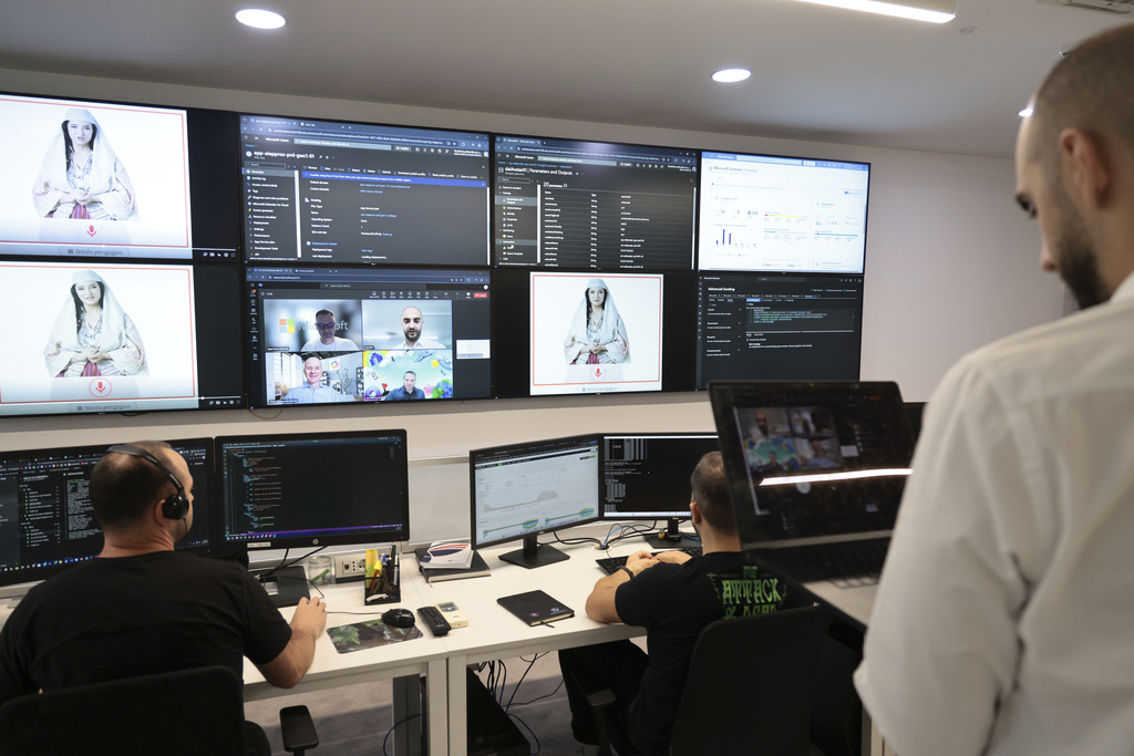 Albanian experts work at the National Agency for Information Society as an artificial intelligence "minister" Diella, whose name means "Sun" in Albanian, is seen on the screens in Tirana, Albania, Friday, Sept. 12, 2025. (AP Photo/Vlasov Sulaj)