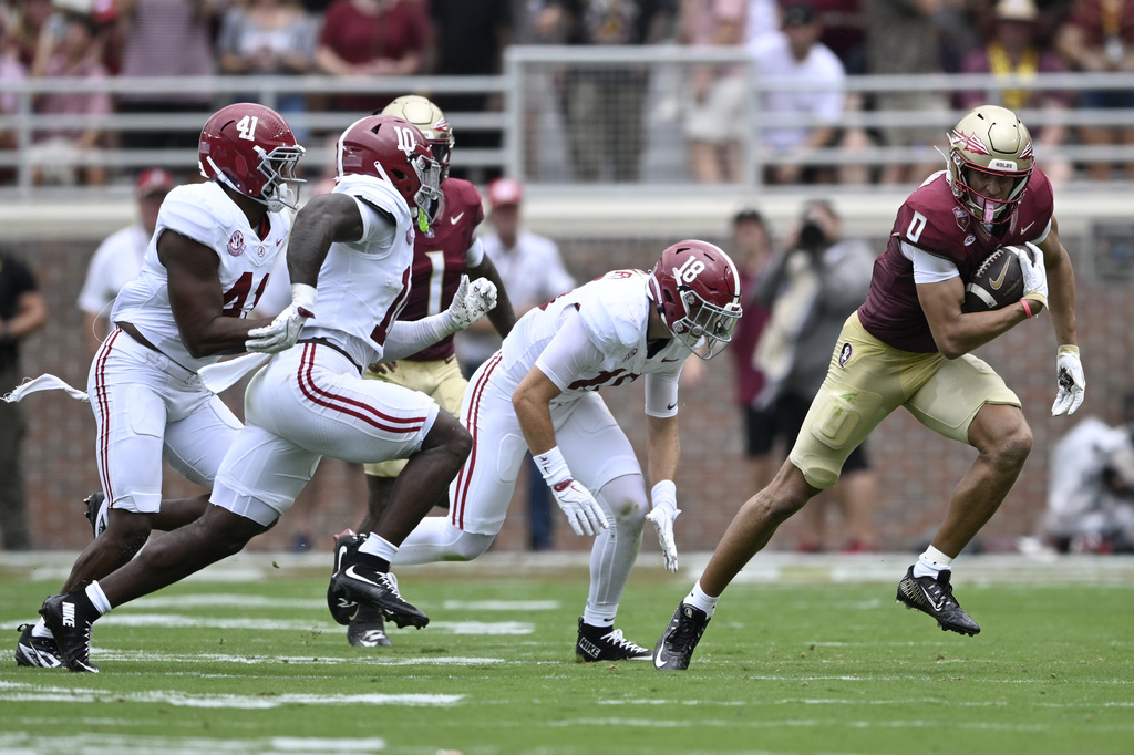 Florida State wide receiver Duce Robinson (0) runs after catching a pass in front of Alabama linebacker Nikhai Hill-Green (41), linebacker Justin Jefferson (10) and defensive back Bray Hubbard (18) during the first half of an NCAA college football game, Saturday, Aug. 30, 2025, in Tallahassee, Fla. (AP Photo/Phelan M. Ebenhack)
