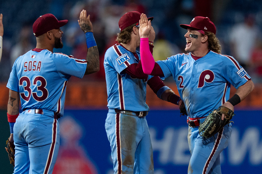 Philadelphia Phillies' Harrison Bader, right, celebrates the win with second baseman Bryson Stott, center, and shortstop Edmundo Sosa, left, following a baseball game against the Miami Marlins, Thursday, Sept. 25, 2025, in Philadelphia. (AP Photo/Chris Szagola)