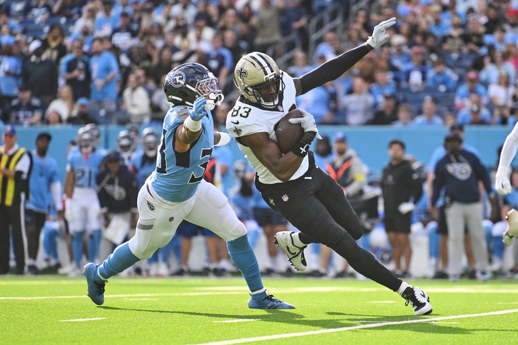 New Orleans Saints tight end Juwan Johnson (83) pulls in a first down reception against Tennessee Titans linebacker Cedric Gray (33) in the second half of an NFL football game, Sunday, Dec. 28, 2025, in Nashville, Tenn. (AP Photo/John Amis)