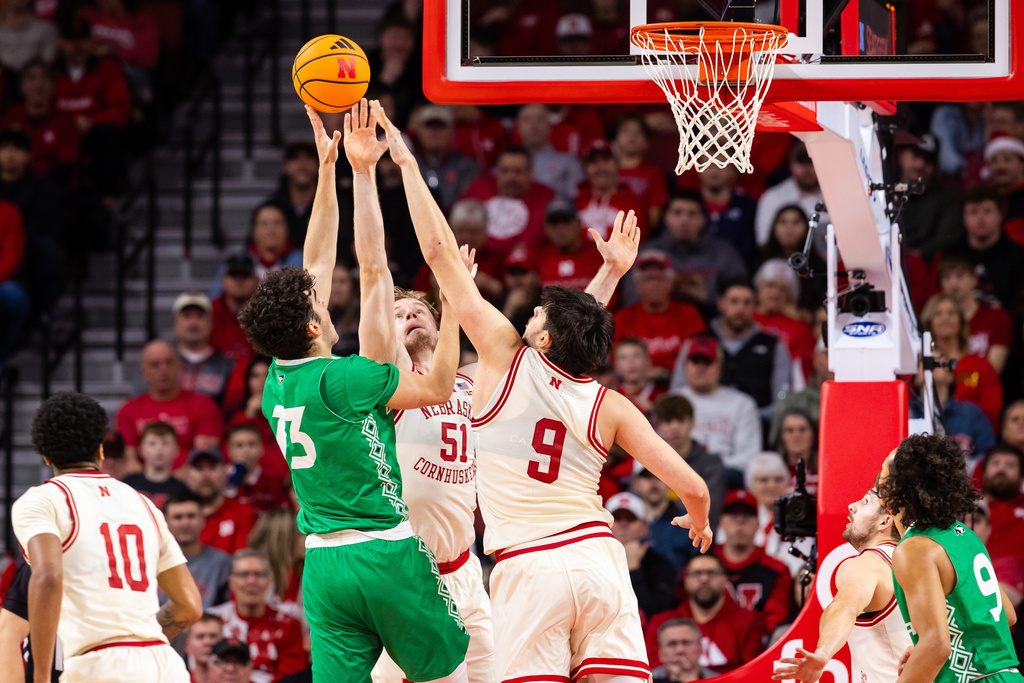 Nebraska forwards Rienk Mast (51) and Berke Büyüktuncel (9) defend against North Dakota forward George Natsvlishvili (13) during the first half of an NCAA college basketball game, Sunday, Dec. 21, 2025, in Lincoln, Neb. (AP Photo/Bonnie Ryan)