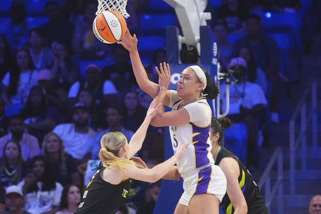 Los Angeles Sparks forward Dearica Hamby (5) moves the ball against Dallas Wings guard Paige Bueckers during the first half of a WNBA basketball game in Arlington, Texas, Friday, Aug. 15, 2025. (AP Photo/LM Otero)