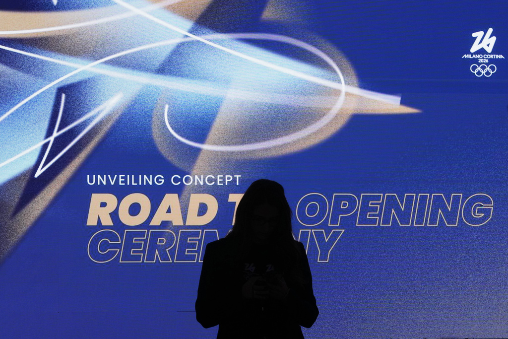 A woman is silhouetted during the Organising Committee for the Olympic and Paralympic Winter Games 2026 press conference unveiling the concept of the opening ceremony of the Milano-Cortina Winter Olympics, at Milan's San Siro stadium, Italy, Thursday, Oct. 16, 2025. (AP Photo/Antonio Calanni)