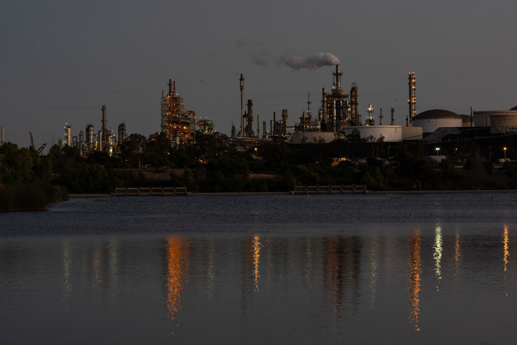 Lights from the Phillips 66 Los Angeles Refinery Wilmington Plant are reflected in the water at dusk, Thursday, Oct. 2, 2025, in Los Angeles. (AP Photo/Jae C. Hong)