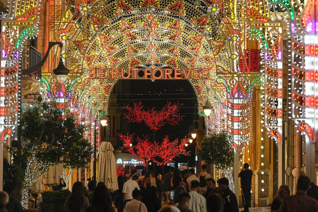 FILE - People walk past Christmas decorations in downtown Beirut, Lebanon, Wednesday, Nov. 26, 2025. (AP Photo/Hussein Malla, File)