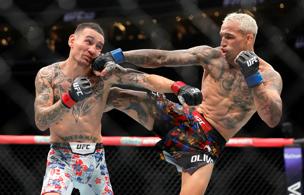 Charles Oliveira, right, punches Max Holloway in a lightweight fight during UFC 326 Saturday, March 7, 2026, in Las Vegas. (Steve Marcus/Las Vegas Sun via AP)/Las Vegas Sun via AP)