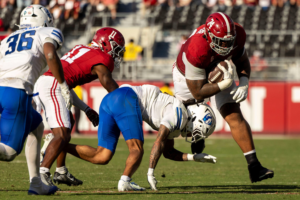 Alabama offensive lineman Kadyn Proctor (74) runs with the ball after a catch against Eastern Illinois defensive back Moses Alexander (4) during the first half of an NCAA college football game, Saturday, Nov. 22, 2025, in Tuscaloosa, Ala. (AP Photo/Vasha Hunt)