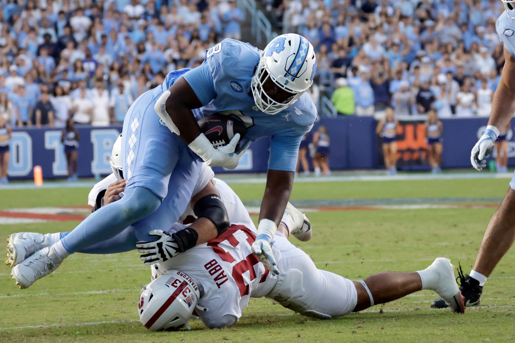 North Carolina defensive end Smith Vilbert (8) is tackled by Stanford running back Cole Tabb (33) after Vilbert recovered a fumble during the first half of an NCAA college football game Saturday, Nov. 8, 2025, in Chapel Hill, N.C. (AP Photo/Chris Seward)