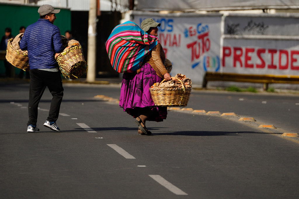 People walk during a strike by the public transportation sector in La Paz, Bolivia, Friday, Dec. 19, 2025, after President Rodrigo Paz announced the end of fuel subsidies. (AP Photo/Freddy Barragan)