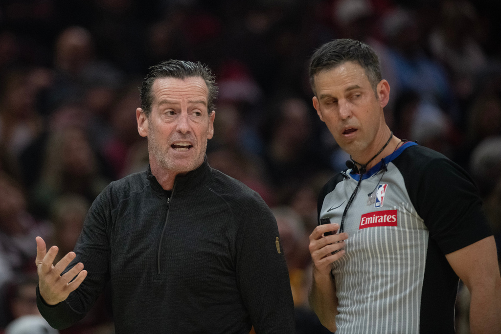 Cleveland Cavaliers head coach Kenny Atkinson, left, speaks with referee Kevin Scott, right, during the first half of an NBA basketball game, against the Philadelphia 76ers in Cleveland, Wednesday, Nov. 5, 2025. (AP Photo/Phil Long)