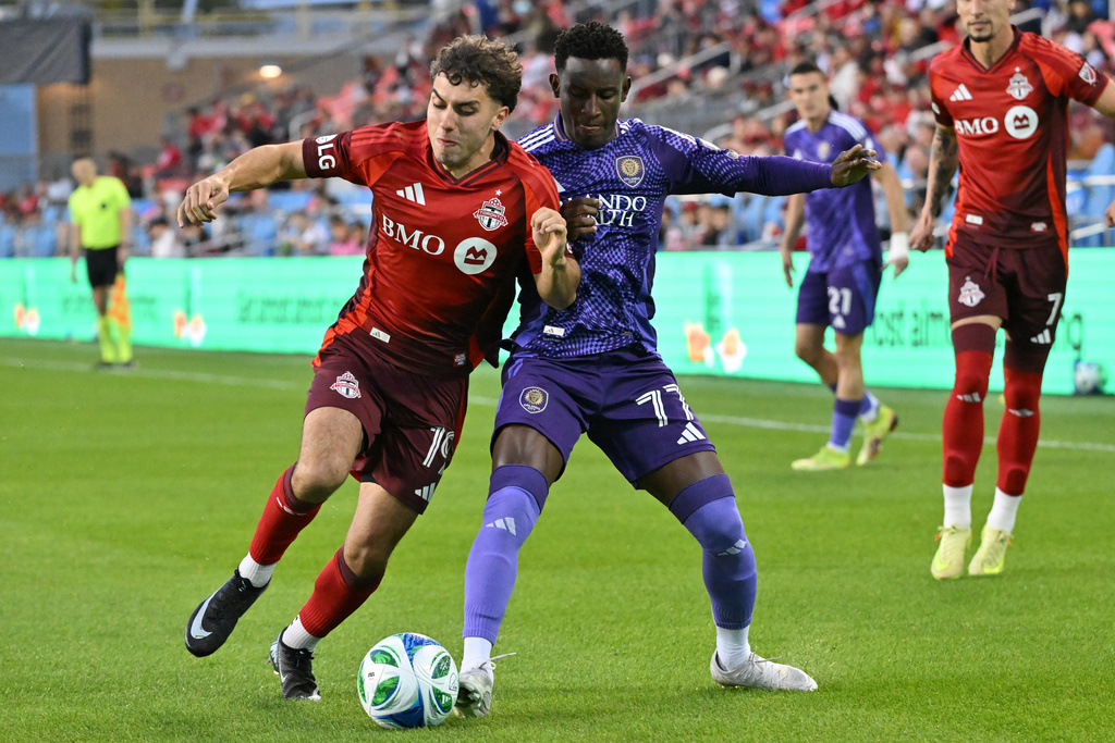 Toronto FC's Kobe Franklin (19) fights for the ball against Orlando City SC's Ivan Angulo during first half MLS soccer action in Toronto on Saturday, Oct. 18, 2025. (Jon Blacker/The Canadian Press via AP)