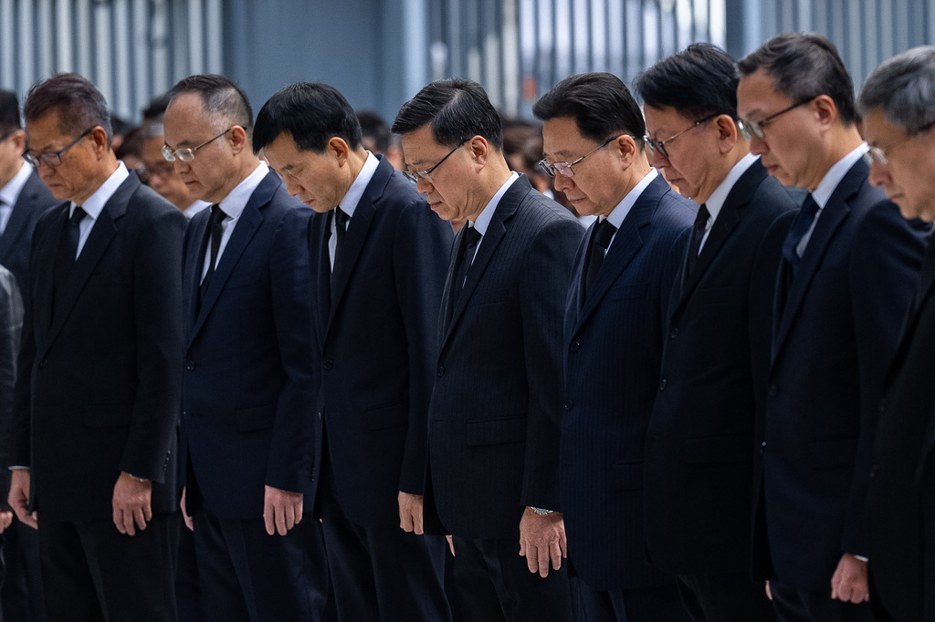 Hong Kong Chief Executive John lee, center and other officers observe a moment of silence for the victims of the deadly fire that started Wednesday at Wang Fuk Court, a residential estate in the Tai Po district of Hong Kong's New Territories, Saturday, Nov. 29, 2025. (AP Photo/Chan Long Hei)